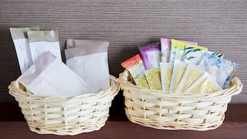 Two wicker baskets containing various packaged items, likely toiletries, on a wooden surface against a textured wall.