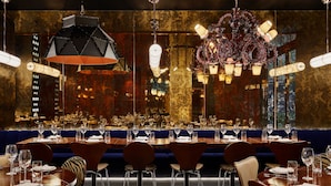 A restaurant with multiple dining tables, chairs, and hanging chandeliers.