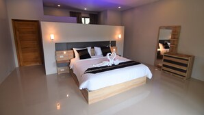 Un dormitorio moderno con una cama grande, mesitas de noche, un aparador de madera y un espejo.