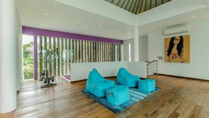 A spacious room with a wooden floor, a large window with a view of greenery, and a ceiling with a unique design. - Phocea Golf View Villa by Premier Hospitality Asia (Pecatu)