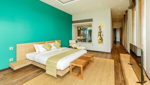 A modern bedroom with a teal accent wall, a wooden bed frame, a bedside table, and a large window with blinds. - Phocea Golf View Villa by Premier Hospitality Asia (Pecatu)