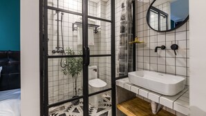 A modern bathroom with a glass-enclosed shower, a white sink, and a mirror on the wall. - Floral Hotel Xiamen Menglou (Xiamen)