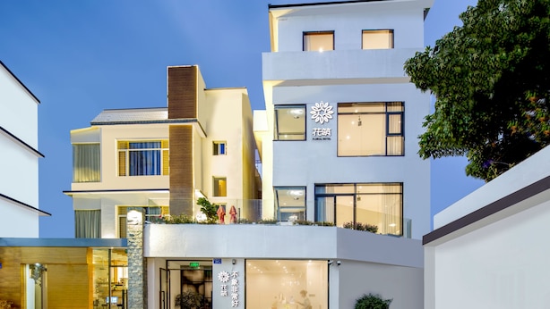 A modern hotel with a multi-story structure, large windows, and a well-lit entrance. - Floral Hotel Xiamen Buxiang Inn (Xiamen)