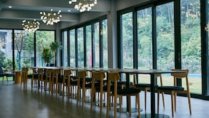 A long dining table with chairs, large windows, and hanging lights. - Floral Hotel Ningbo Zhuye (Ningbo)