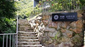 A stone staircase leading to a building with a sign that reads "Floral Hotel Pastoral Peace". - Floral Hotel Ningbo Zhuye (Ningbo)