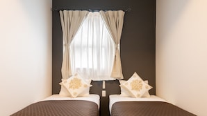 Una habitación con dos camas, cada una con ropa de cama estampada y almohadas decorativas.