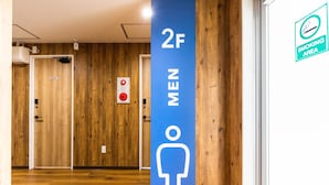 Baño de hombres con un letrero azul que indica que está en el segundo piso.