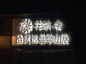 A sign with Chinese characters and a floral design, likely indicating the name of a hotel or establishment.