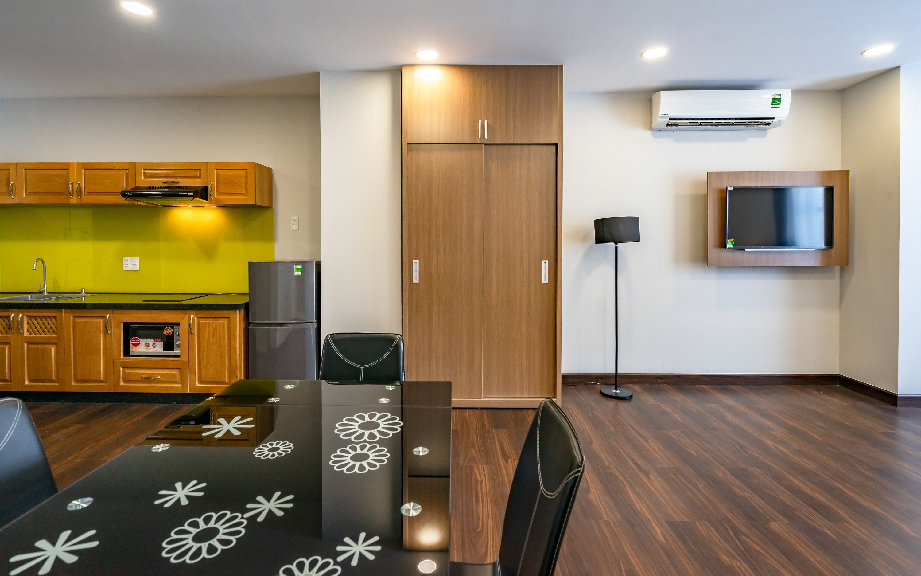 A compact kitchen with wooden cabinets, a built-in oven, and a refrigerator.