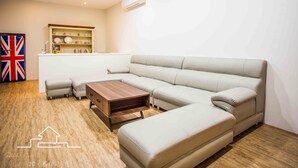 A modern living room with a sectional sofa, a wooden coffee table, and a built-in shelving unit against the wall. - shih.kuang (Tainan)