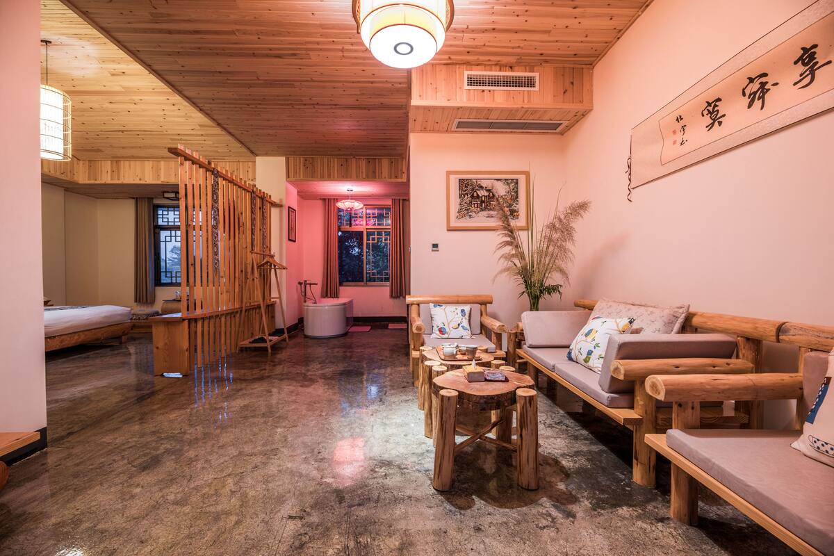 A traditional Japanese-style room with tatami flooring, a low wooden table, and a sofa with cushions.