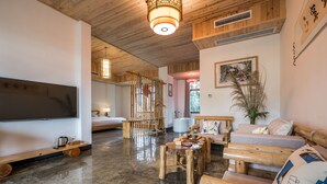 A wooden interior with a sofa, a small table, and a TV mounted on the wall. - Floral Hotel Chengdu Dujiangyan (Chengdu)
