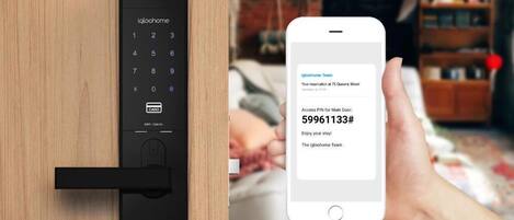 Cerradura digital con teclado y un teléfono inteligente mostrando un mensaje del equipo de igloohome.
