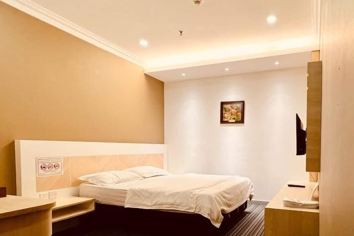 Ein Hotelzimmer mit einem Bett, einem Schreibtisch, einem Stuhl und einem Papierkorb.