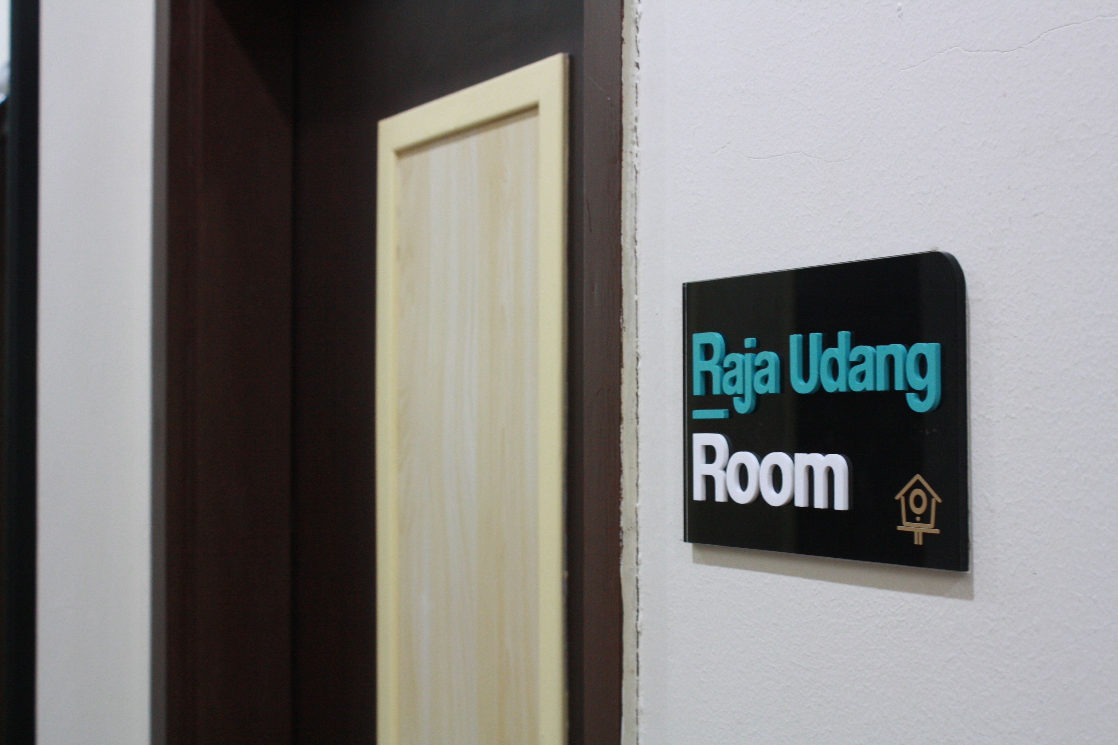 A sign indicating 'Raja Ulang Room' with a house icon.