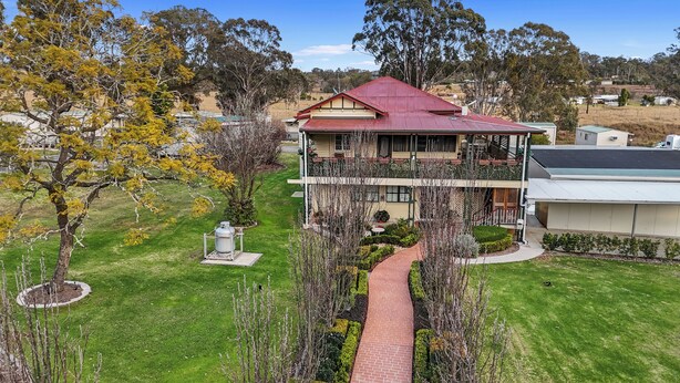 A two-story house with a red roof, a balcony, and a well-maintained lawn. - Crows Nest Tourist Park (Crows Nest)