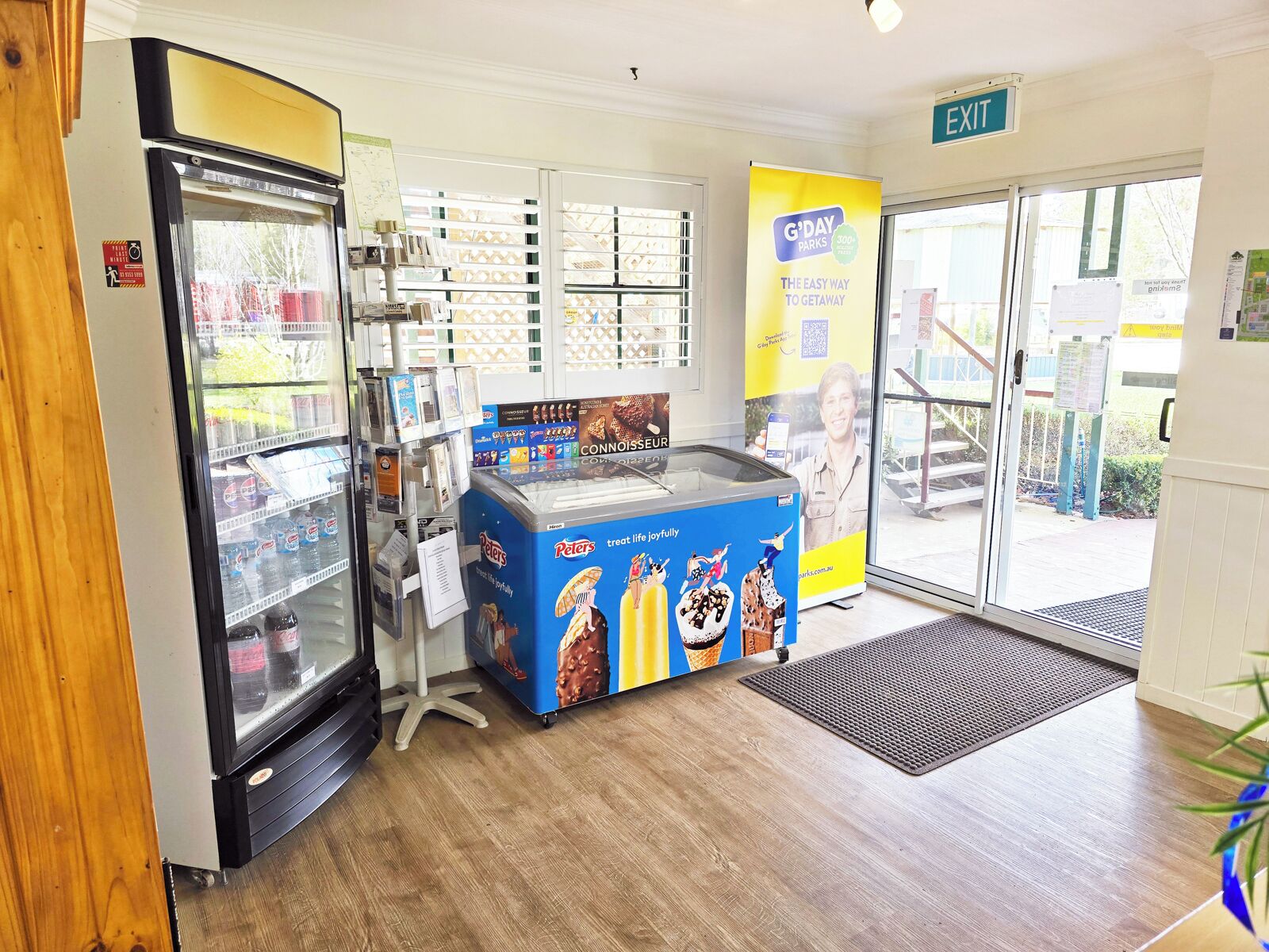 Una gelateria self-service con diversi gusti, una vetrina refrigerata e un cartello di uscita ben visibile.
