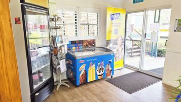 Una gelateria self-service con diversi gusti, una vetrina refrigerata e un cartello di uscita ben visibile.