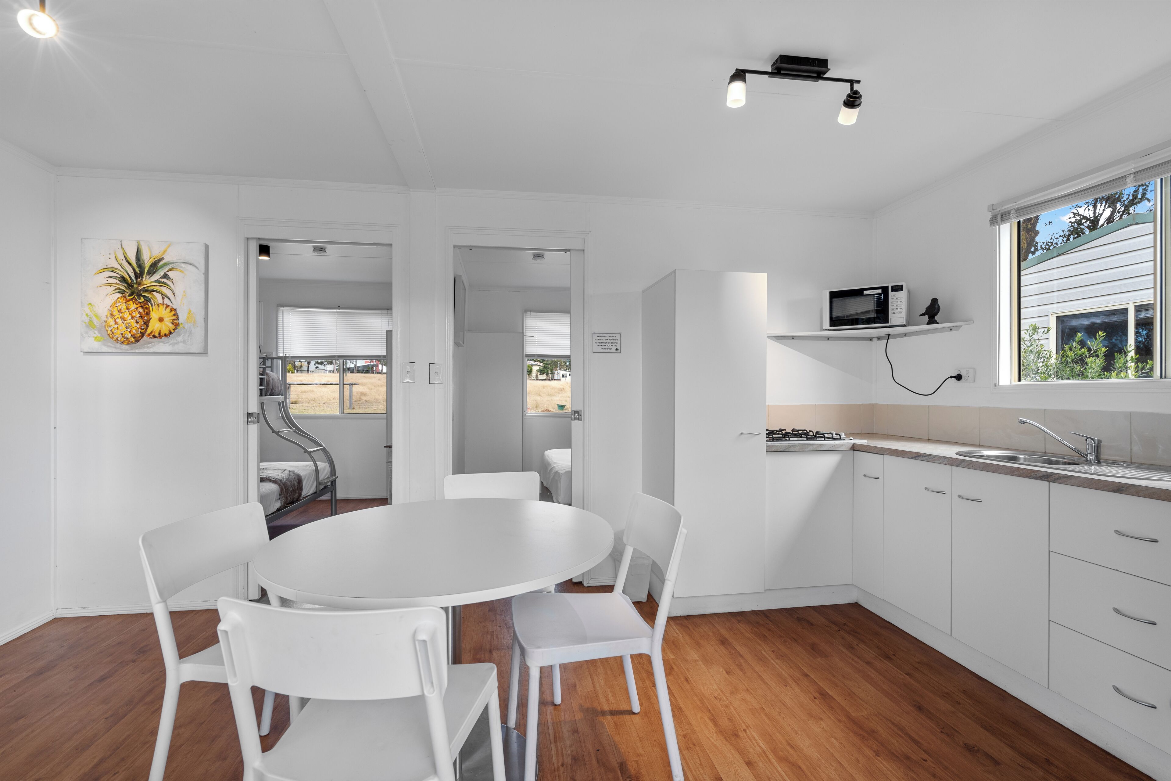 Una cocina moderna con armarios blancos, un microondas y una ventana con vistas.