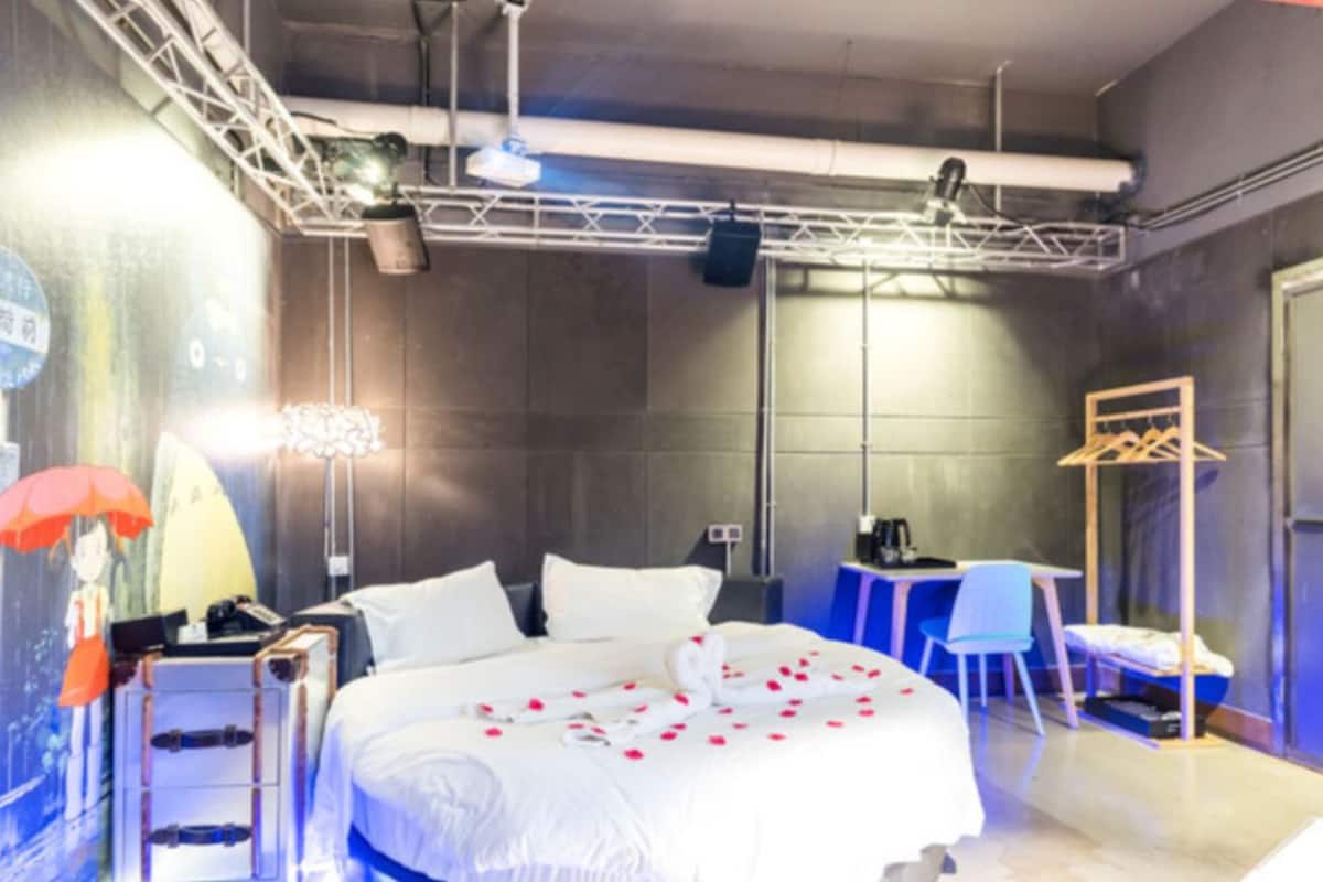 Una habitación de hotel con una cama, una mesita de noche y un escritorio con una silla.