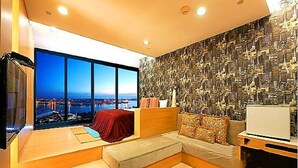 A modern living room with a large window, a sofa, a TV, and a laptop on a table. - 85 Prague Homestay (Kaohsiung)