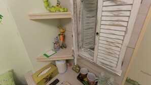 A room with a rustic wooden door, shelves with decorative items, a desk with a keyboard, and a small window. - Mei Di Ya Ju Guest House (Yuli)