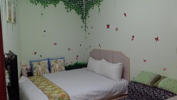 A bedroom with a bed, pillows, and a wall decorated with butterfly decals.
