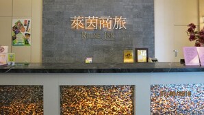 A hotel reception desk with a sign reading "Rhine Inn" and a date stamp of "07/09/2018". - Rhineinn Hotel (Keelung)