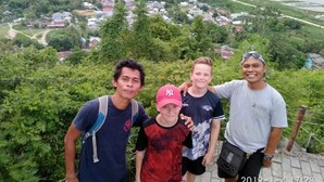 A group of people standing on a high vantage point overlooking a town with a river. - Harry & Mimin Homestay (Gorontalo)