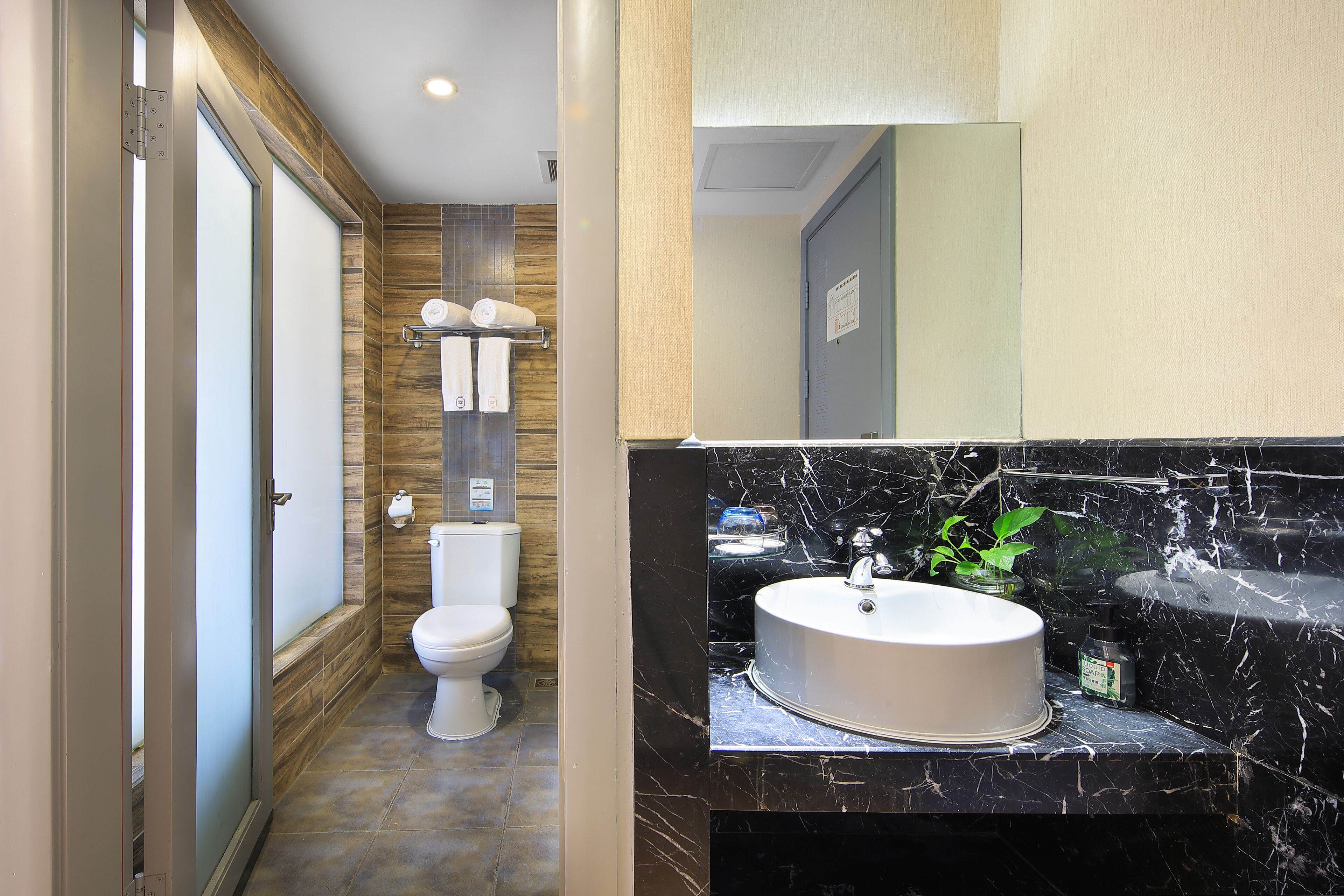 A modern bathroom with a toilet, sink, and a mirror.