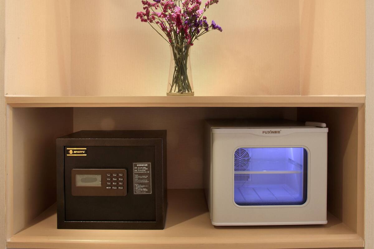 A storage unit with a radio, a microwave, and a basket of slippers.