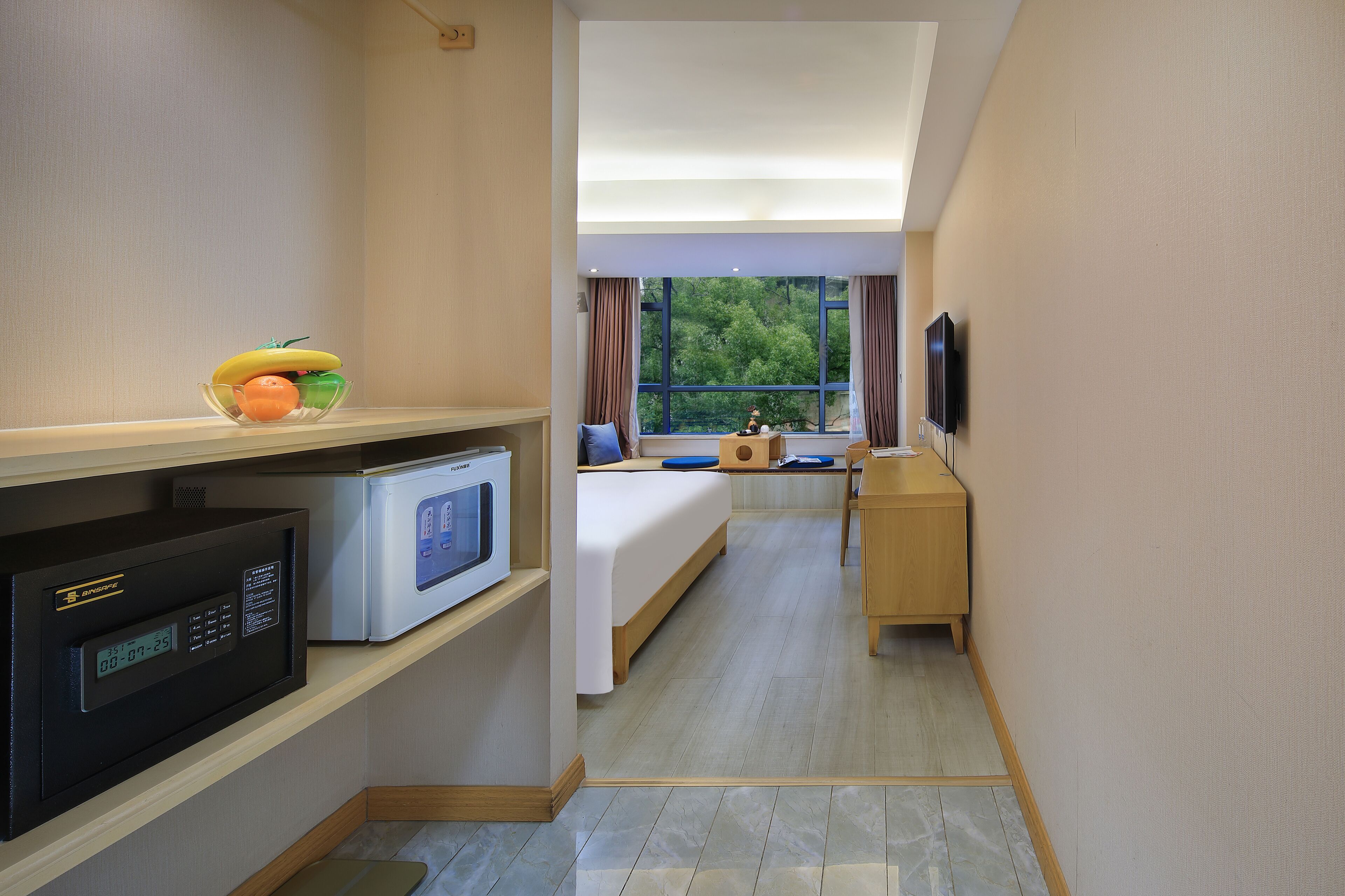 A hotel room with a bed, a desk, a microwave, and a TV.