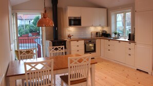 Een moderne keuken met witte kasten, een houten eettafel en stoelen.