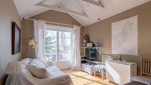 Een gezellige kamer met een bed, bureau, televisie en een kaart aan de muur.