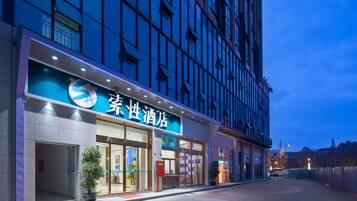 A hotel with a modern facade, large windows, and a prominent sign.