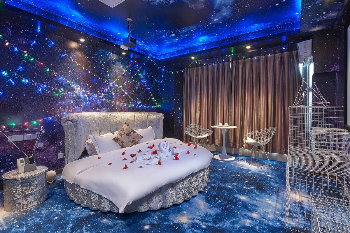 A bedroom with a bed, a nightstand, a chair, and a small table.
