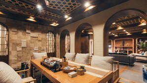 A spacious room with a wooden dining table, comfortable seating, and a cozy fireplace area. - Floral Hotel Wuxi Qietintfengyin Resort (Wuxi)
