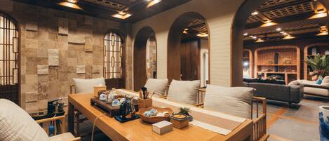 A spacious room with a wooden dining table, comfortable seating, and a cozy fireplace area.