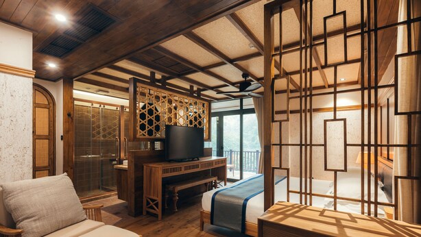 A room with a bed, a desk, and a seating area. - Floral Hotel Wuxi Qietintfengyin Resort (Wuxi)