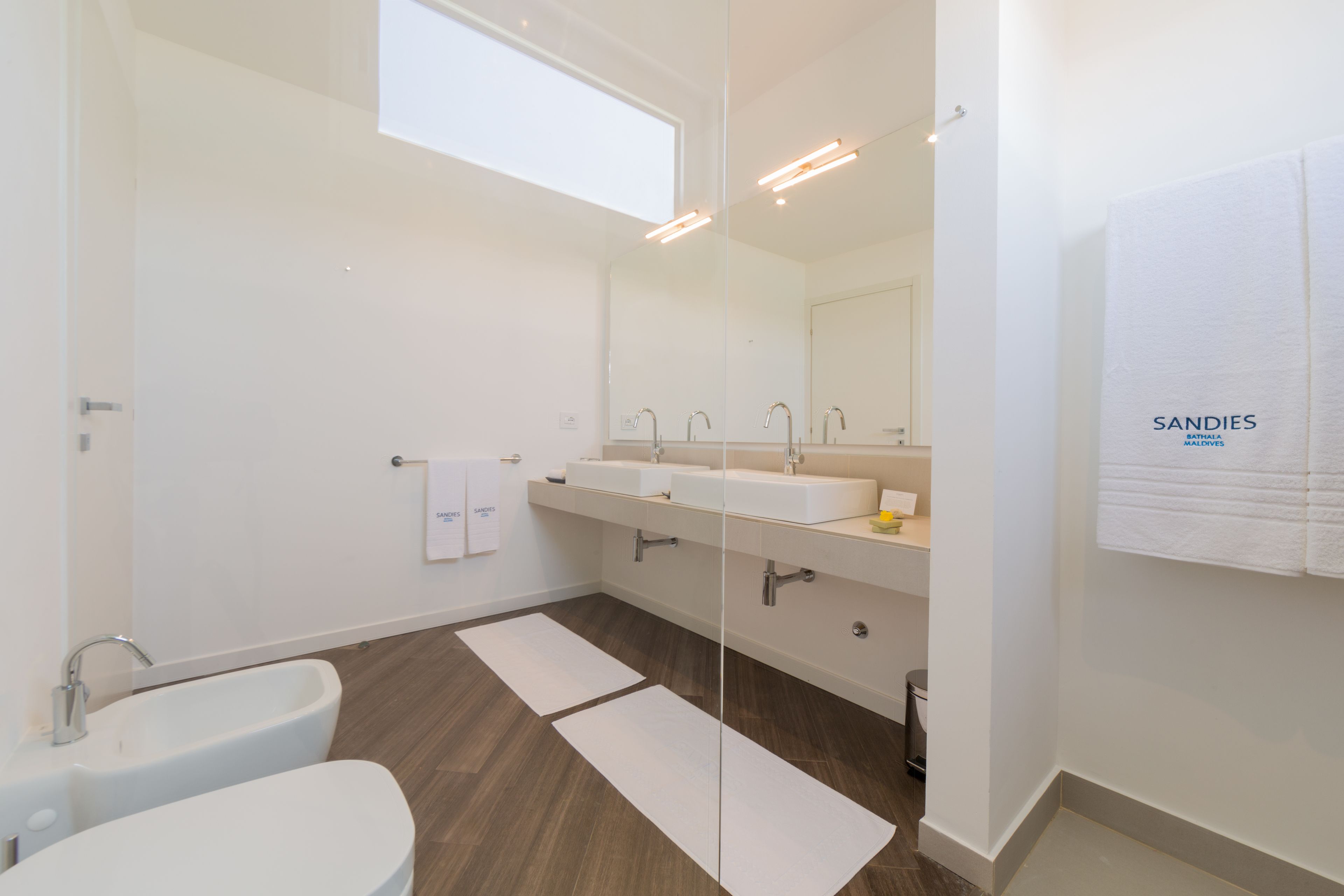 Un bagno moderno con una vasca, due lavandini e un ampio specchio.