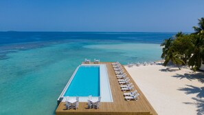 Una piscina al aire libre, sillones reclinables de piscina