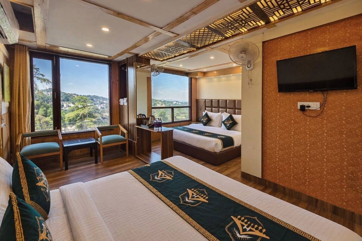 A hotel room with a bed, a desk, a chair, a TV, and a balcony with a view.
