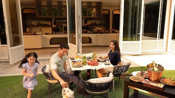 An outdoor dining area with a table set for four, surrounded by chairs.