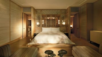 A spacious bedroom with a large bed, wooden paneling, and a decorative screen.