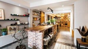 A modern kitchen with a brick island, wooden shelves, and a variety of decorative items. - Floral Hotel Hangzhou Nuanshuyiju (Hangzhou)