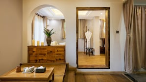 A room with a wooden dresser, a mirror, and a table with tea sets. - Floral Hotel Hangzhou Nuanshuyiju (Hangzhou)
