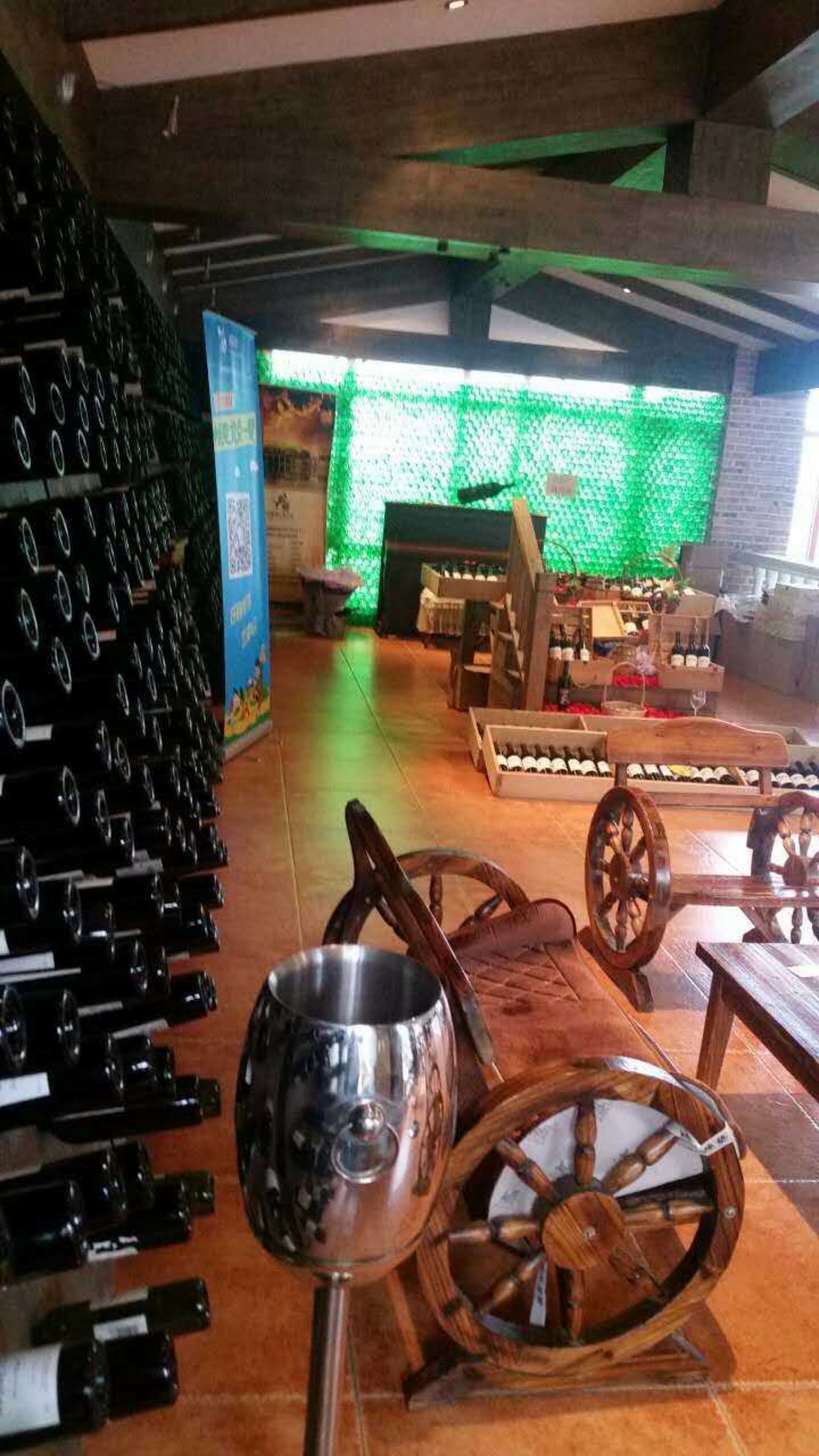 A wine cellar with rows of wine bottles, a wooden barrel, and a wine rack.