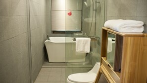 A modern bathroom with a glass-enclosed shower, a white bathtub, and a wooden vanity with a mirror. - Floral Hotel Hangzhou Jiulinjingshe (Hangzhou)