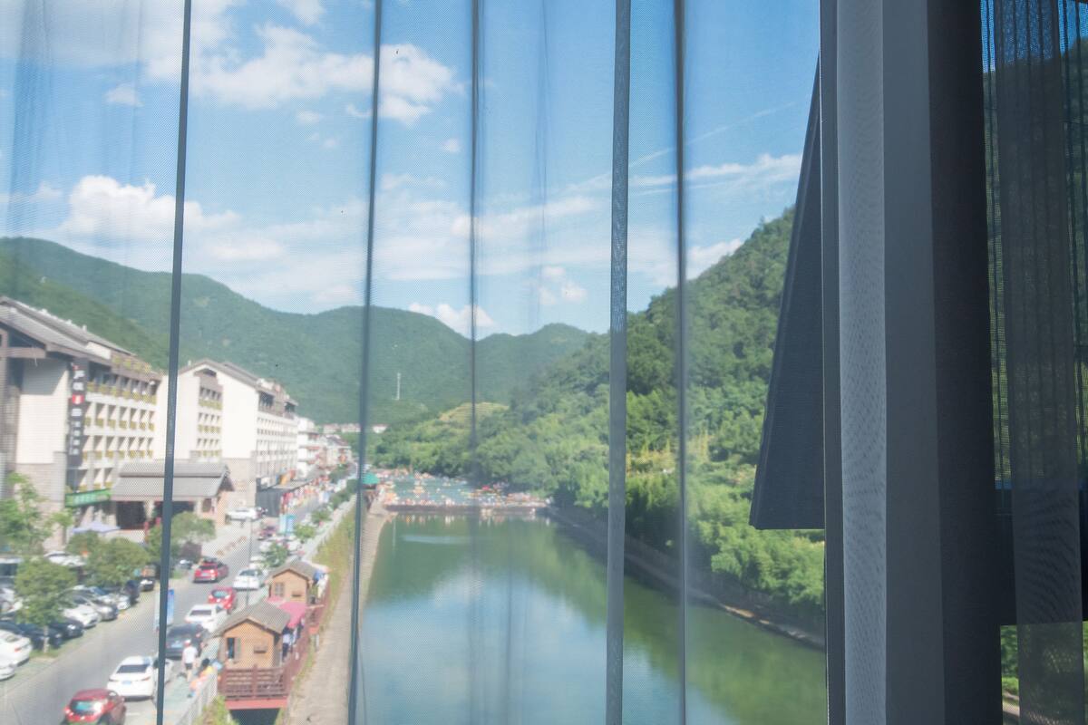 A river with buildings on one side and hills on the other.