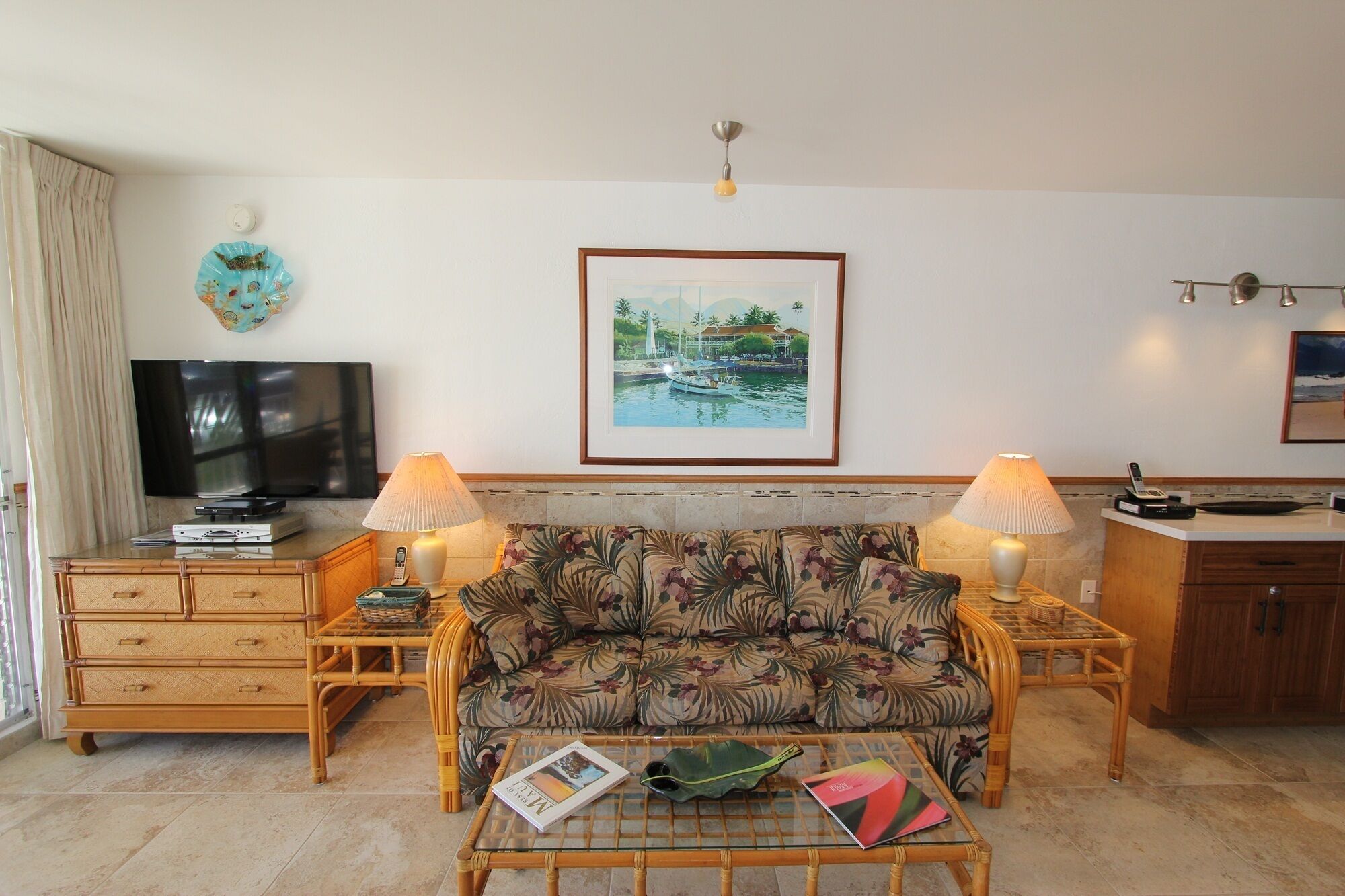 A living room with a sofa, a coffee table, a TV, and a framed picture on the wall.